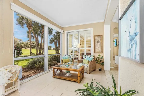 a living room with furniture and a floor to ceiling window