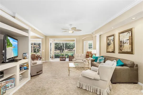 a living room with furniture a flat screen tv and a large window