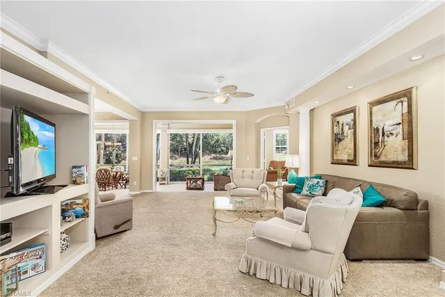 a living room with furniture a flat screen tv and a large window