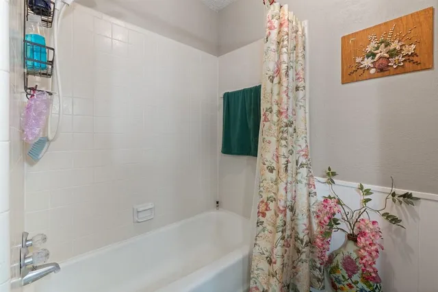 a bathroom with a bathtub sink and shower curtain