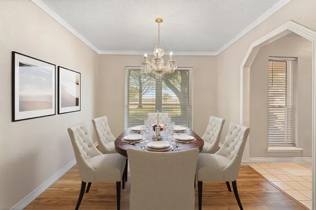 a dining room with furniture a chandelier and wooden floor