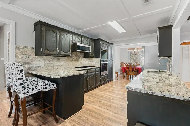a kitchen with kitchen island granite countertop a stove refrigerator and cabinets