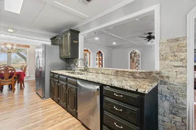 a bathroom with a granite countertop sink a mirror and shower