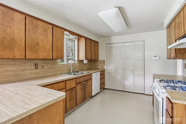 a kitchen with a sink a stove and cabinets