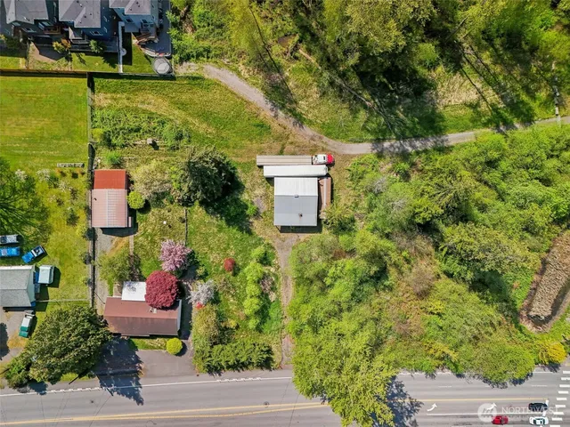an aerial view of a house with a yard lake house and trees in the background