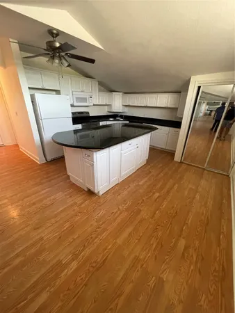 a view of kitchen with wooden floor and electronic appliances