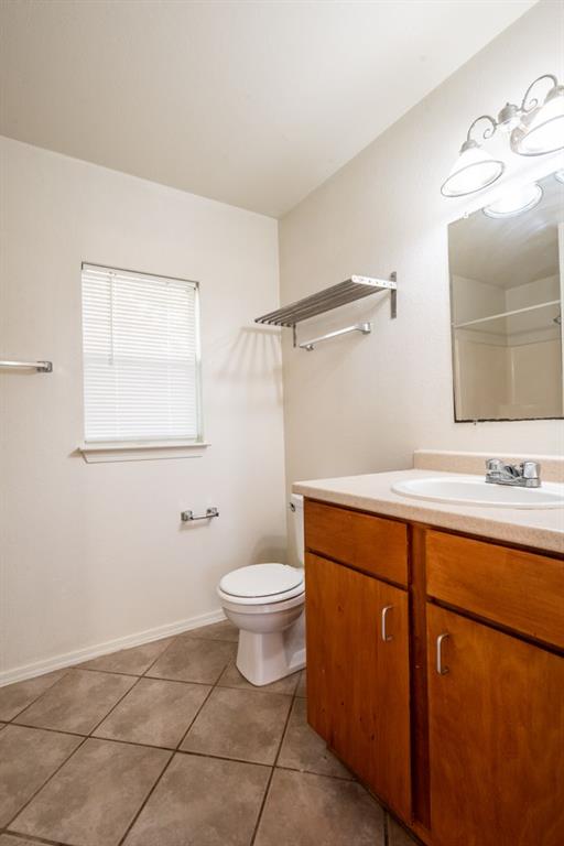 4704 Evans Avenue, Unit B Austin, TX 78751 - Photo 5 of 8 Full bathroom featuring vanity, dark tile patterned floors, and a shower