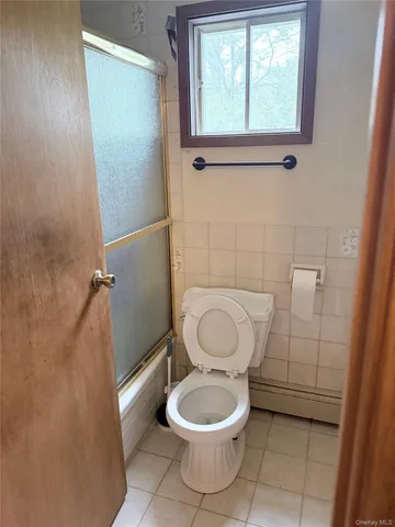 a white toilet sitting next to a bathroom sink and a window