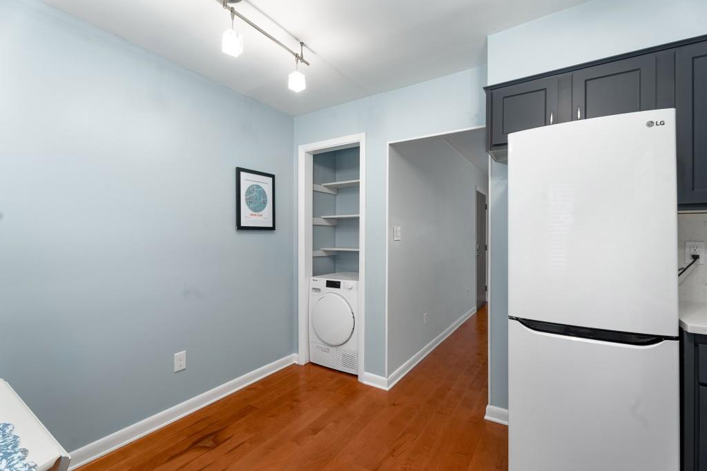 148 Waverly Way Northeast, Unit 6 Atlanta, GA 30307 - Photo 4 of 32 a view of a refrigerator in kitchen and an empty room with wooden floor