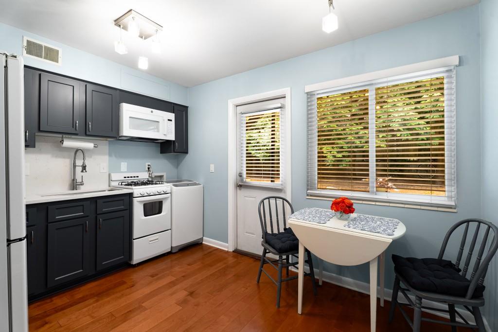 148 Waverly Way Northeast, Unit 6 Atlanta, GA 30307 - Photo 10 of 32 a kitchen with a table chairs sink and cabinets