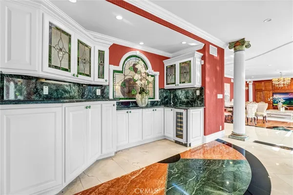 a kitchen with stainless steel appliances kitchen island granite countertop a refrigerator a stove a sink dishwasher and white cabinets with wooden floor