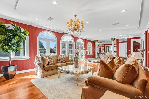 a living room with furniture chandelier and a large window