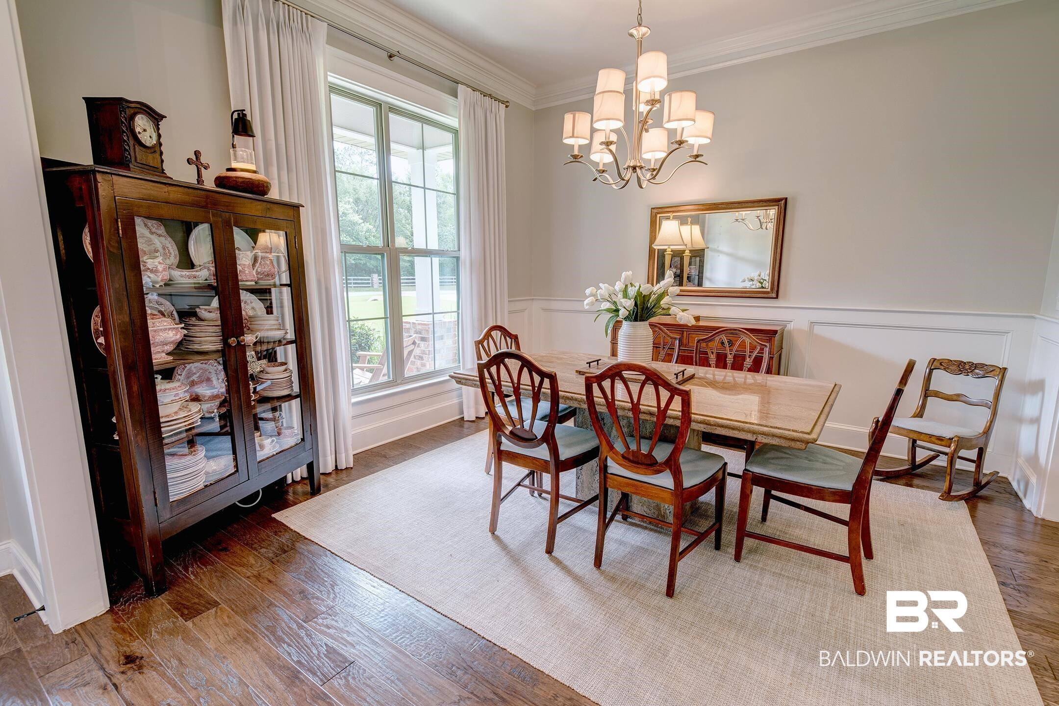 18754 Treasure Oaks Road Gulf Shores, AL 36542 - Photo 9 of 53 Spacious dining area featuring wood-finish flooring, white wainscoting, and a multi-pane window