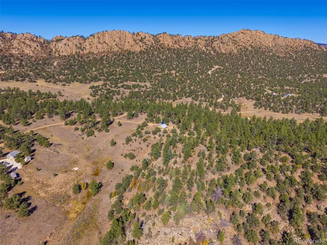 a view of a dry yard with mountains in the background