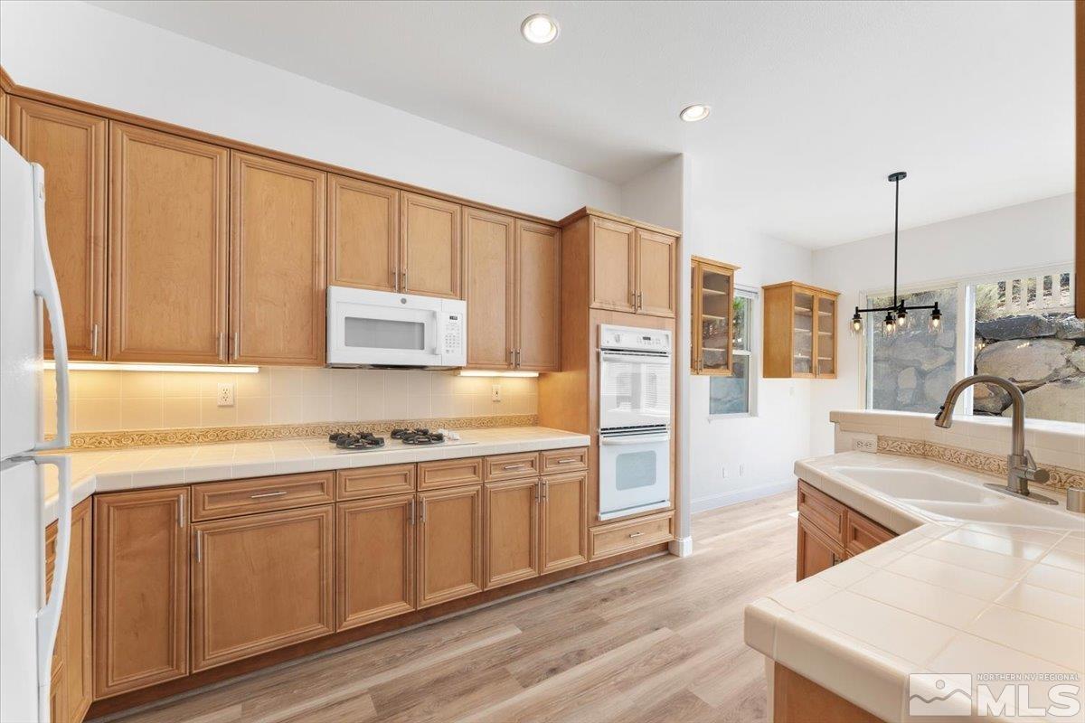 1730 Hunter Creek Road Reno, NV 89519 - Photo 16 of 39 a kitchen with stainless steel appliances granite countertop a sink a stove and a wooden floors