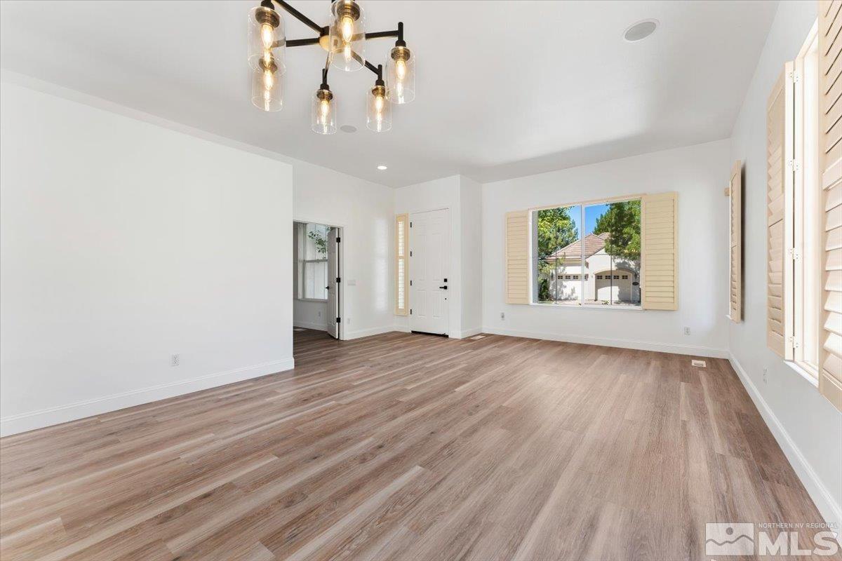 1730 Hunter Creek Road Reno, NV 89519 - Photo 7 of 39 an empty room with wooden floor chandelier and windows