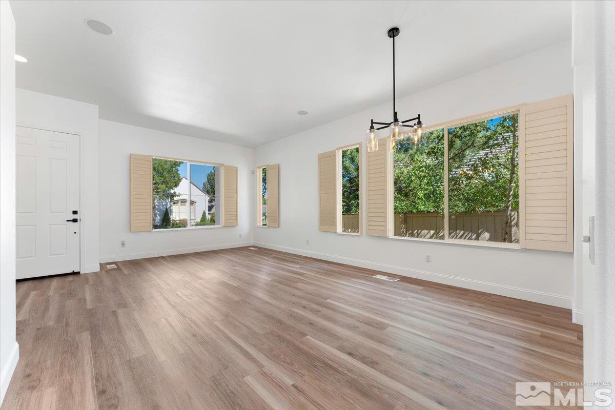 1730 Hunter Creek Road Reno, NV 89519 - Photo 8 of 39 a view of an empty room with wooden floor and a window