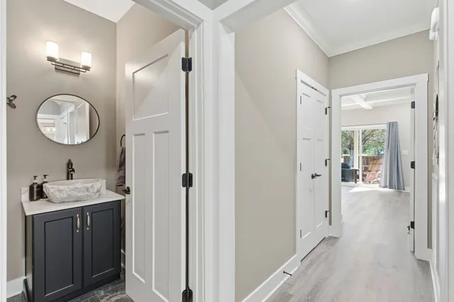 a large kitchen with stainless steel appliances kitchen island granite countertop a refrigerator a stove a sink and white cabinets with wooden floor