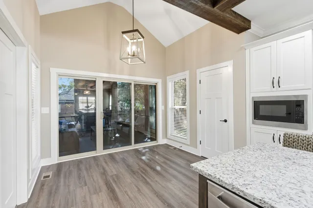 a bedroom with a bed and a large window with wooden floor