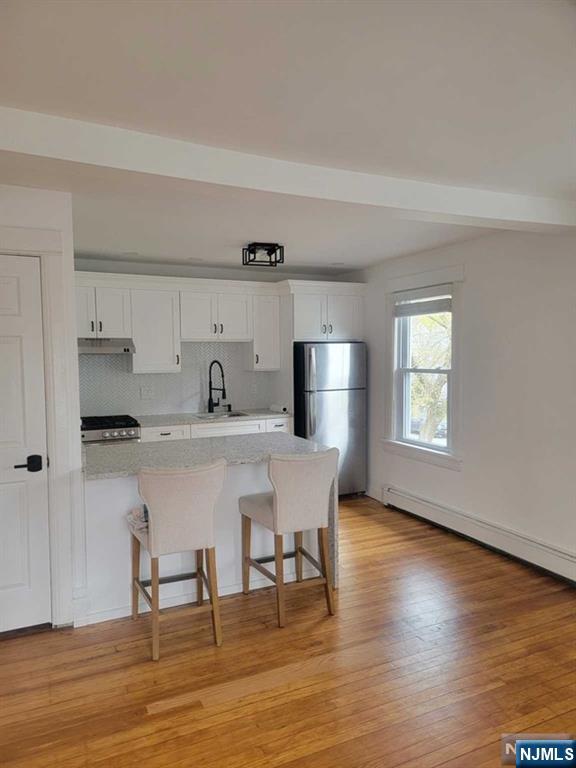 139 Union Place, Unit 2 Ridgefield Park, NJ 07660 - Photo 5 of 14 a kitchen with stainless steel appliances a dining table chairs and wooden floor