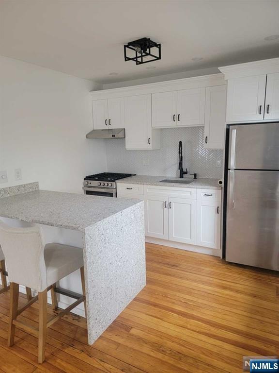 139 Union Place, Unit 2 Ridgefield Park, NJ 07660 - Photo 6 of 14 a kitchen with granite countertop a stove a sink and a refrigerator