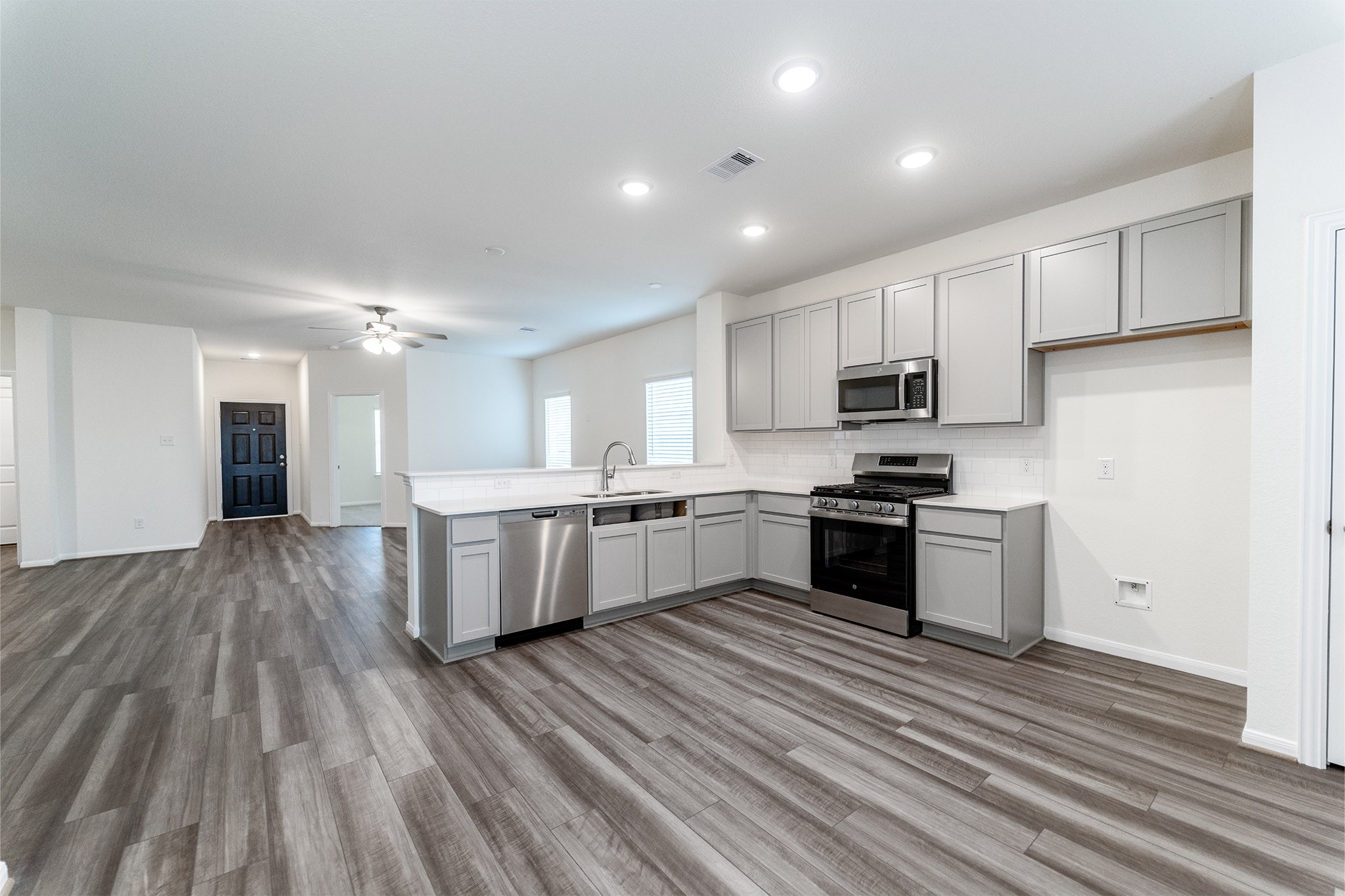 3527 Prairie Rose Trail Angleton, TX 77515 - Photo 3 of 19 a large kitchen with a center island and stainless steel appliances