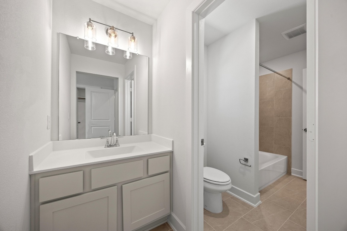 201 Buckaroo Drive Georgetown, TX 78633 - Photo 26 of 36 a bathroom with a toilet a sink and a mirror