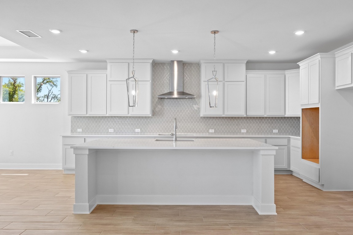 201 Buckaroo Drive Georgetown, TX 78633 - Photo 6 of 36 a kitchen with stainless steel appliances granite countertop a sink a stove a refrigerator and island with wooden floor