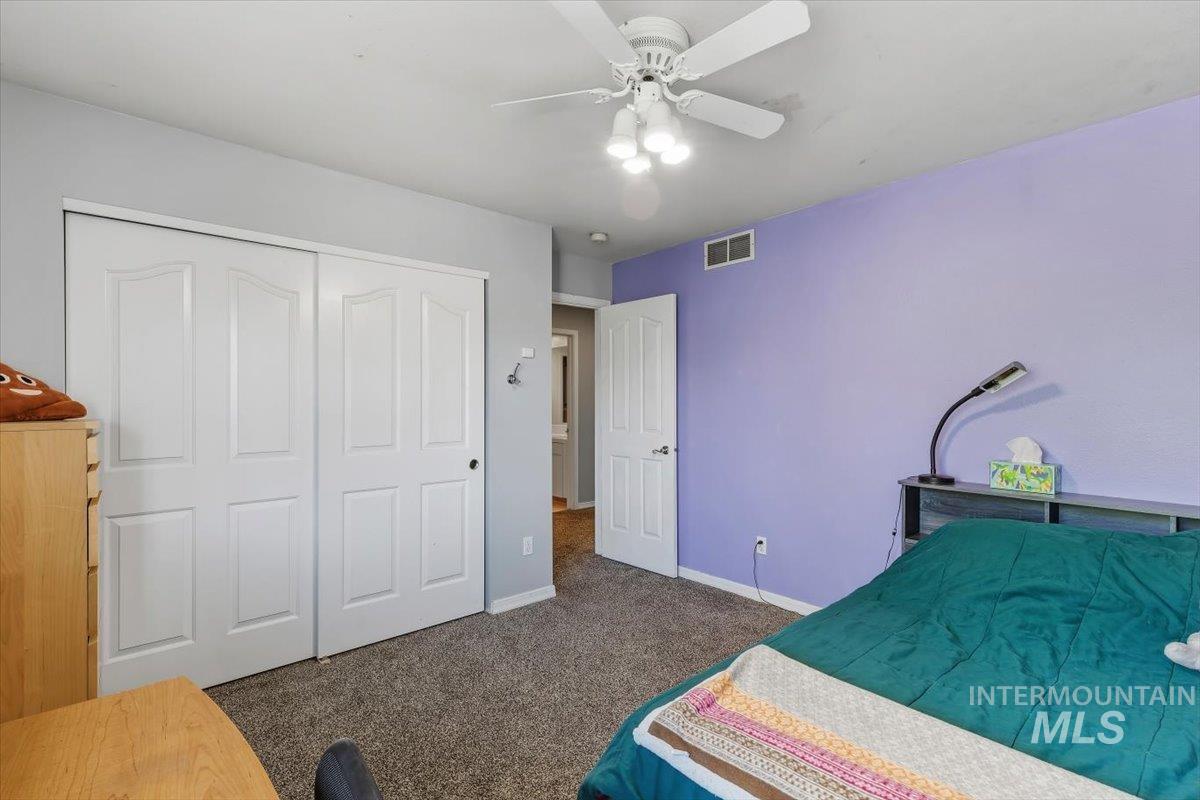 8001 West Innsbrook Court Boise, ID 83704 - Photo 28 of 39 Carpeted room with a ceiling fan light fixture, white bi-fold closet doors, and a paneled white door