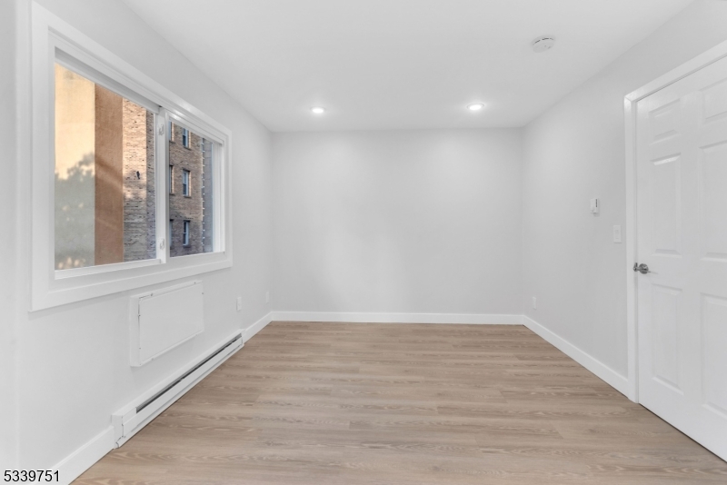 557 South Broad Street, Unit B3 Elizabeth, NJ 07202 - Photo 4 of 9 a view of an empty room with wooden floor and a window