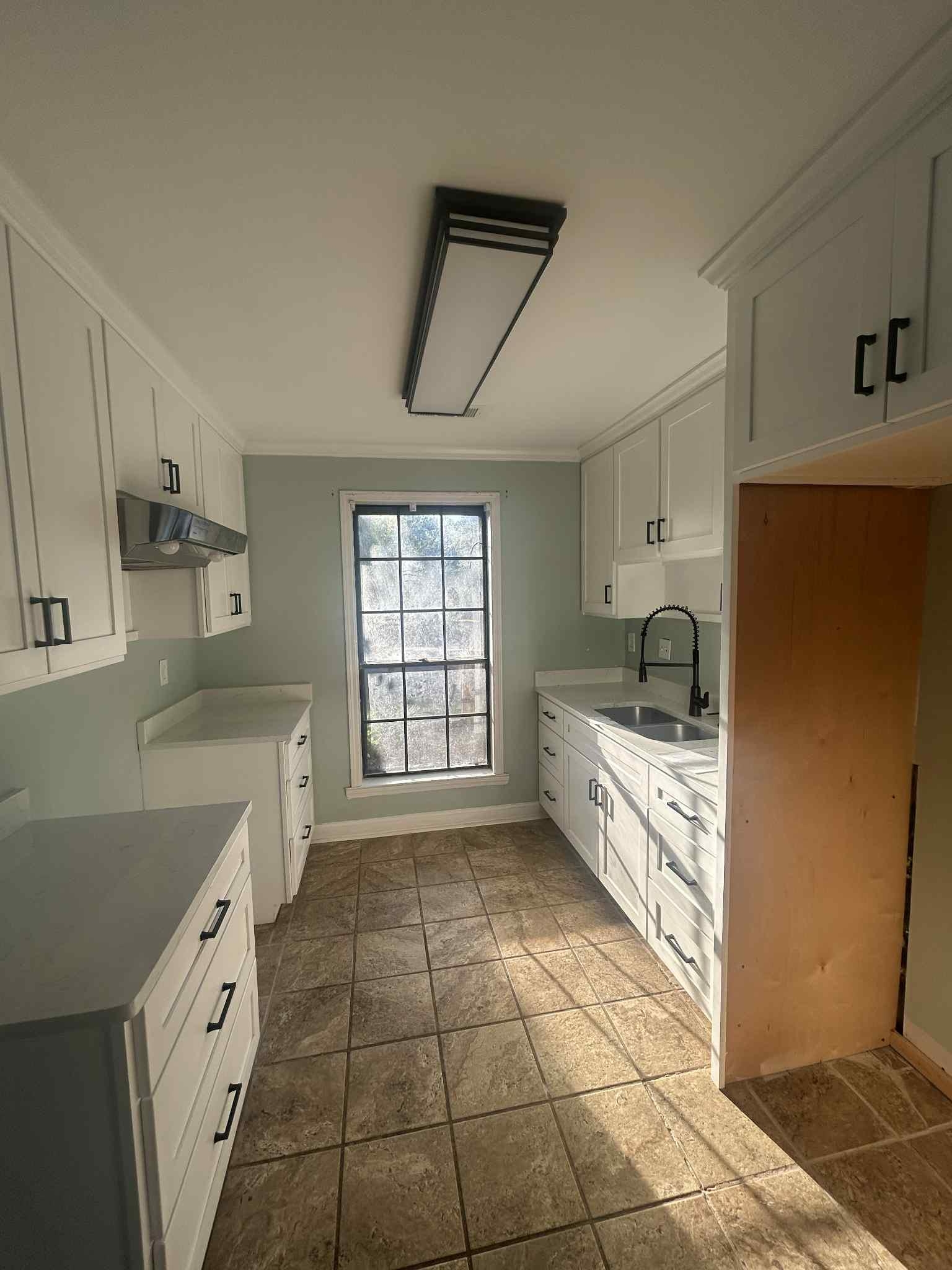 1012 Hunters Point Drive Memphis, TN 38018 - Photo 2 of 10 a large white kitchen with a stove a sink a washer and dryer