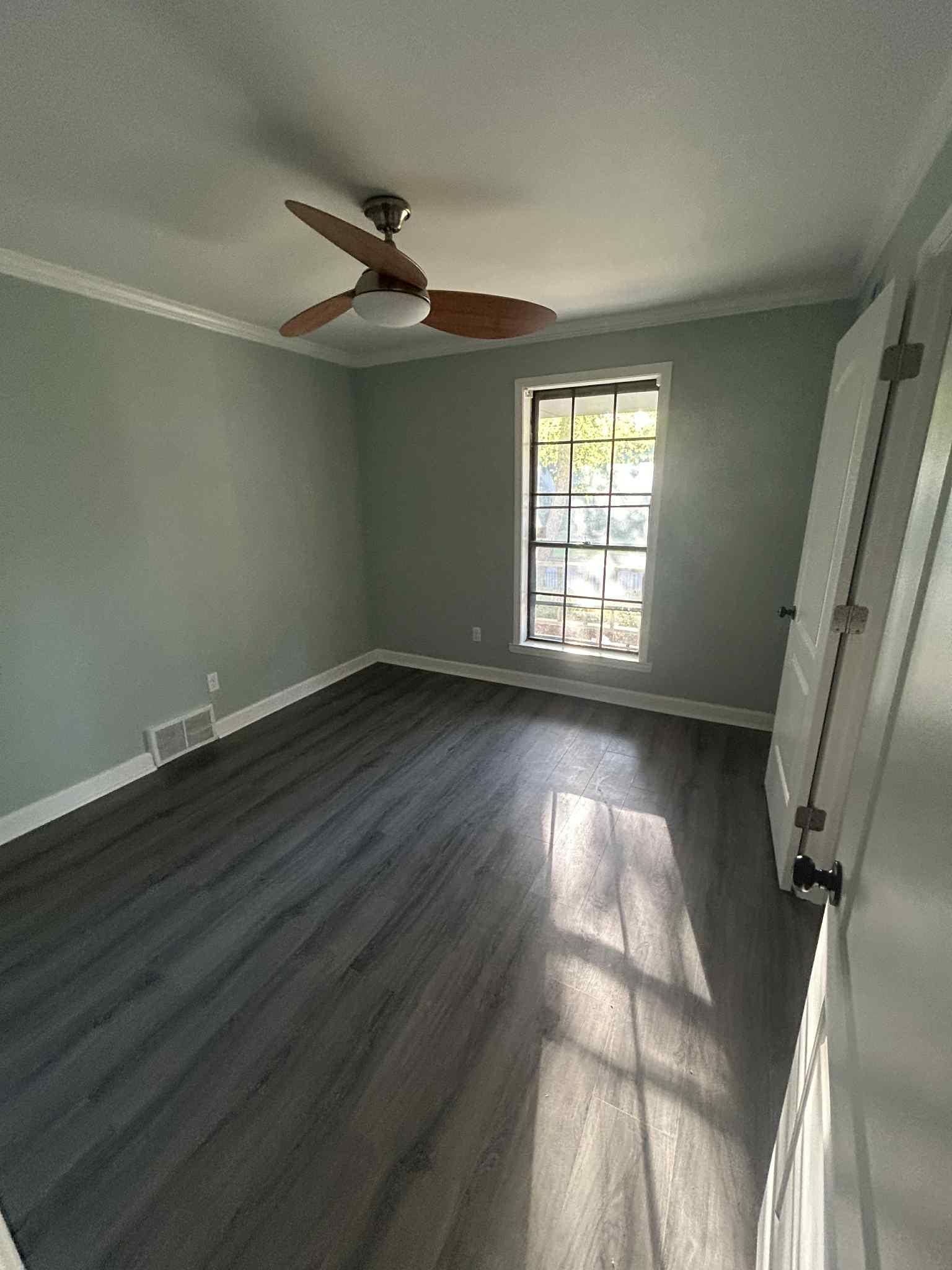 1012 Hunters Point Drive Memphis, TN 38018 - Photo 4 of 10 an empty room with wooden floor and windows