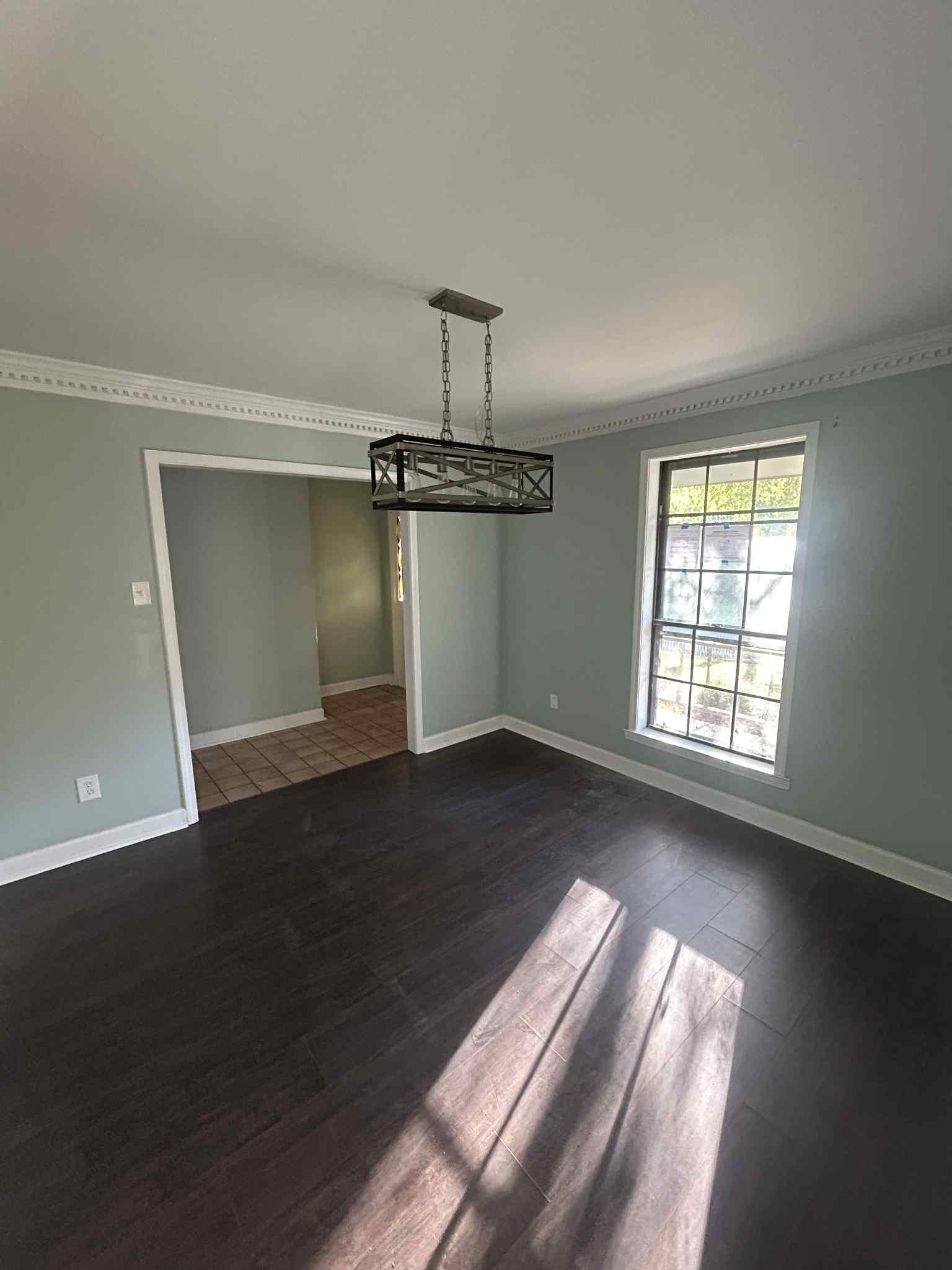 1012 Hunters Point Drive Memphis, TN 38018 - Photo 6 of 10 an empty room with wooden floor cabinet and windows