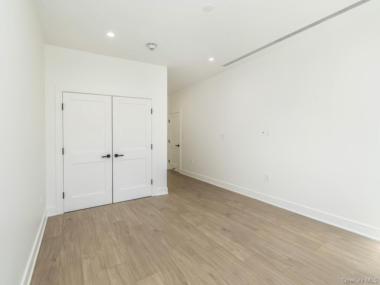 24 Lumber Road, Unit 2 Roslyn, NY 11576 - Photo 16 of 25 an empty room with wooden floor