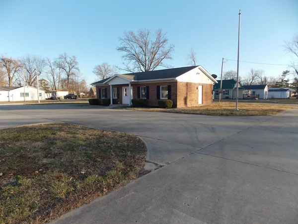 a view of a house next to a yard with big trees