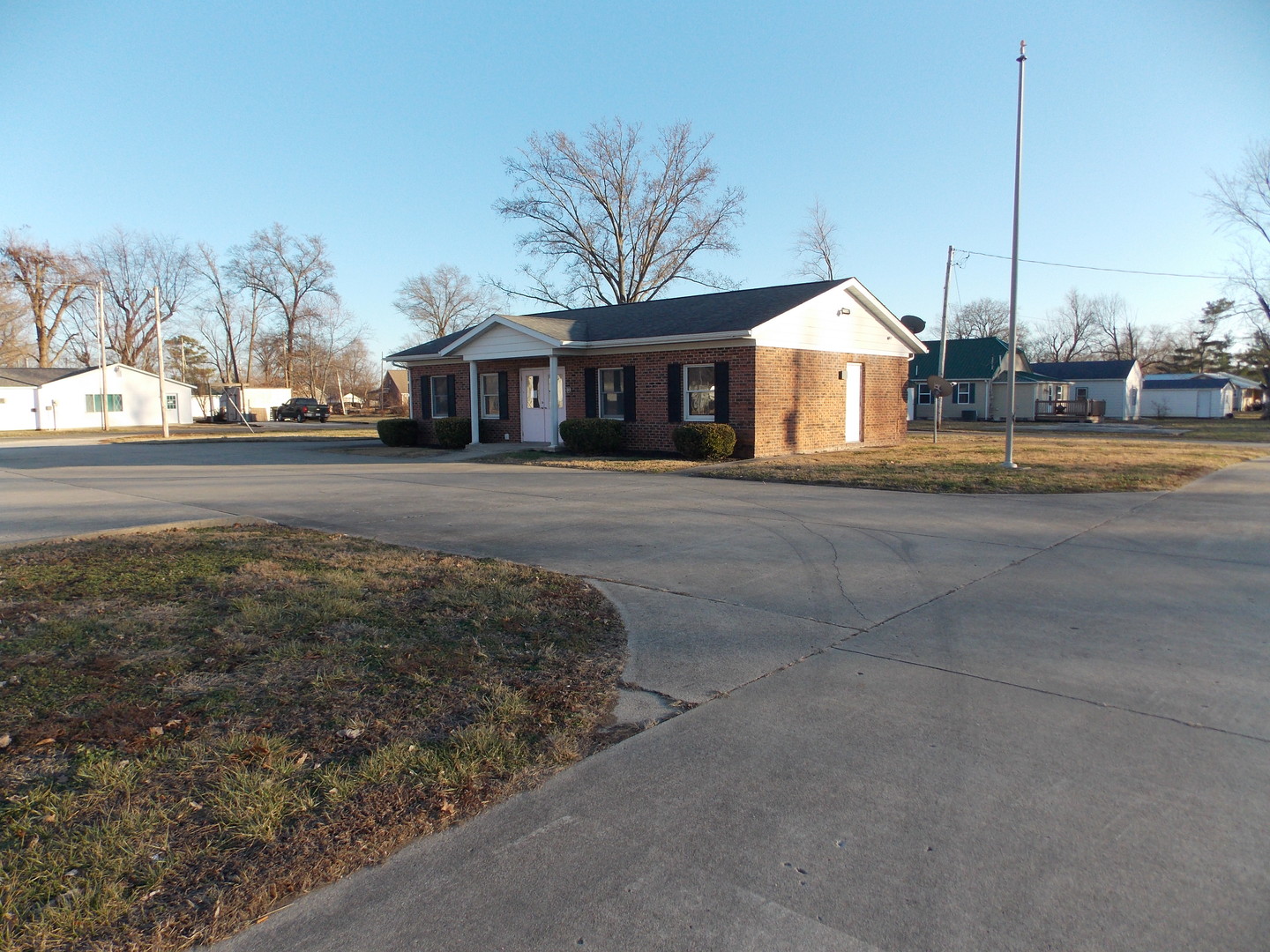 a view of a house next to a yard with big trees