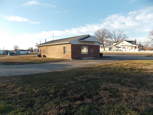 a view of big yard next to a house with large trees