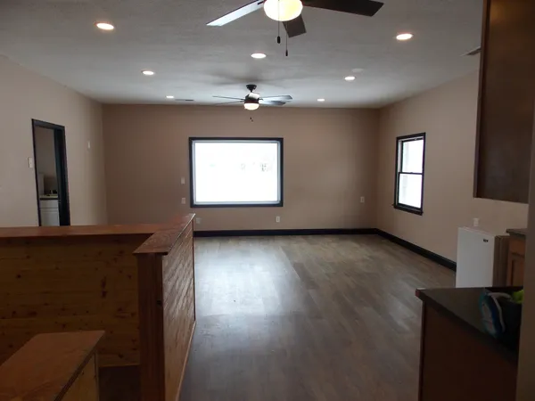 a view of an empty room with a window and wooden floor