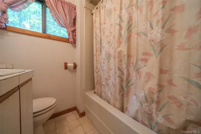 a bathroom with a granite countertop bathtub and toilet