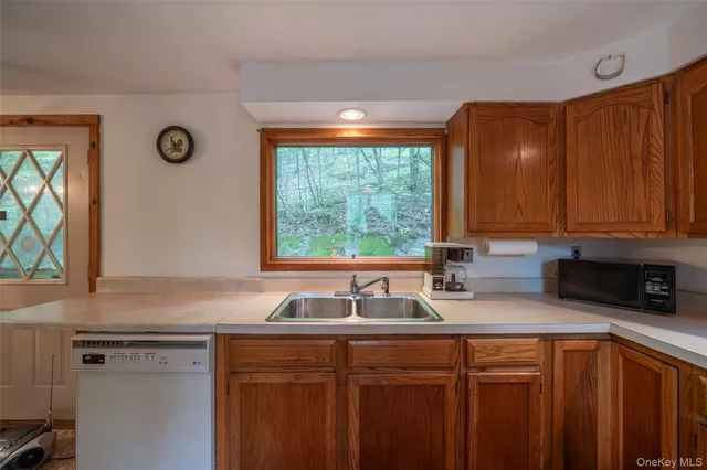 a kitchen with stainless steel appliances granite countertop a sink a refrigerator and a granite counter tops with a window