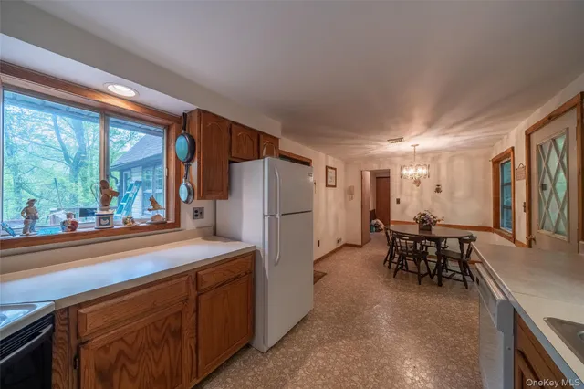 a kitchen with refrigerator and chairs