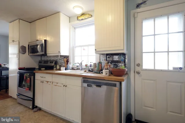 a kitchen with stainless steel appliances granite countertop a sink a stove and a refrigerator