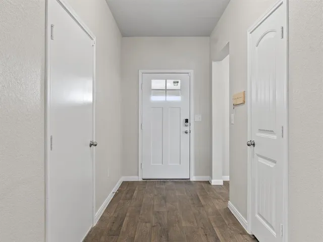 a view of an empty room with closet and mirror