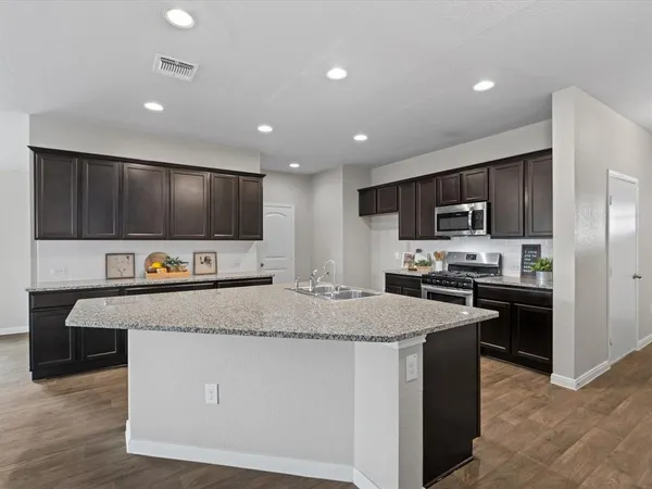 a large kitchen with stainless steel appliances and a refrigerator