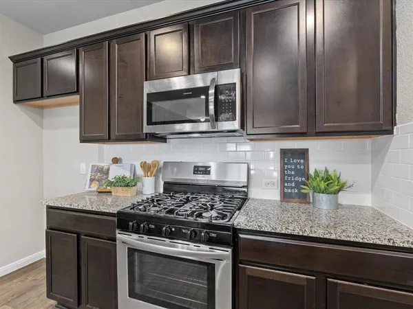 a kitchen with granite countertop stainless steel appliances and cabinets