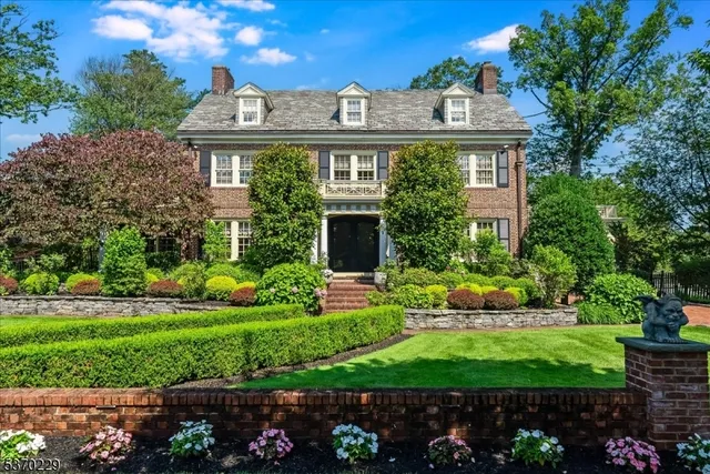 a front view of a house with a yard and potted plants