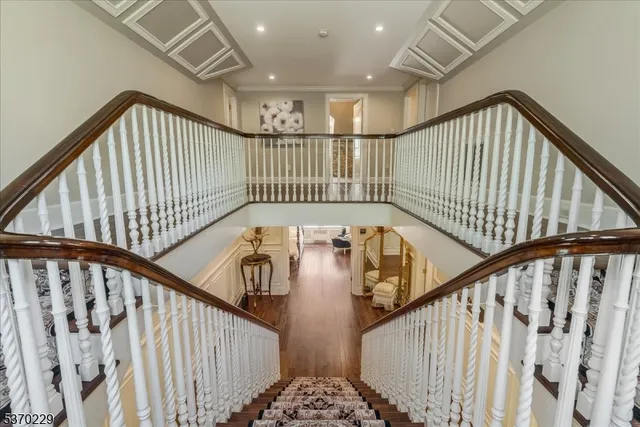 a view of staircase with railing and white walls
