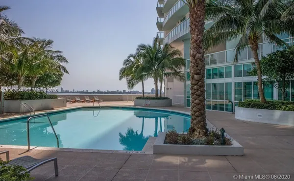 a view of swimming pool with palm trees