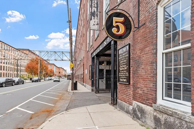 a view of a brick building with a tree in front of it