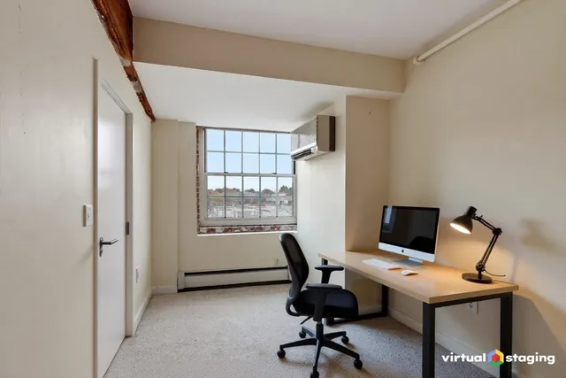 a view of a workspace with furniture and a window